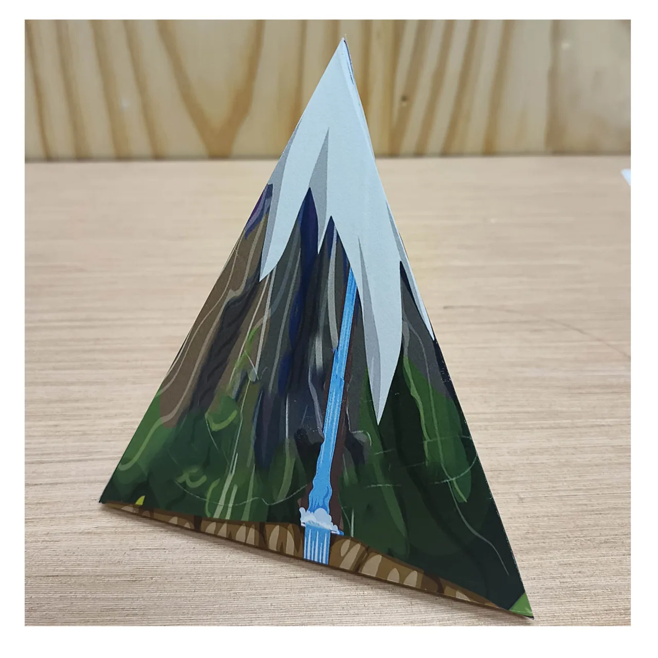 Montaña de papel montada en tres dimensiones con una cascada en la cara frontal