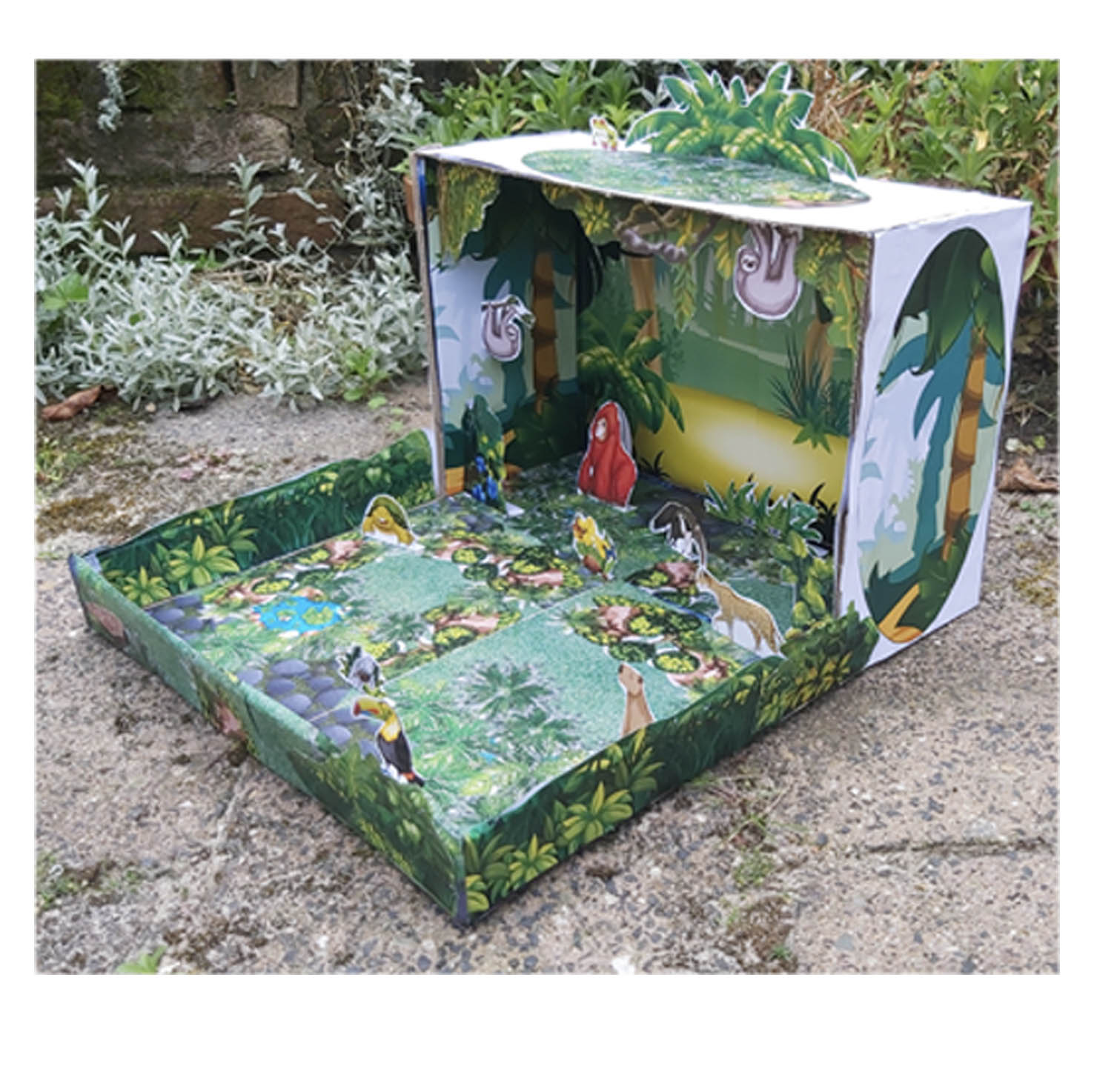 Maqueta de selva con animales tropicales de papel colocados en un escenario 3D