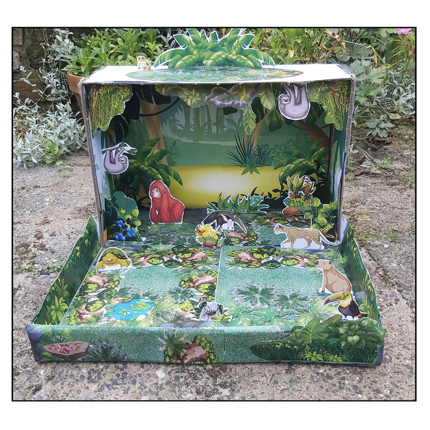 Maqueta de selva fácil para niños construida con una caja y figuras de animales tropicales