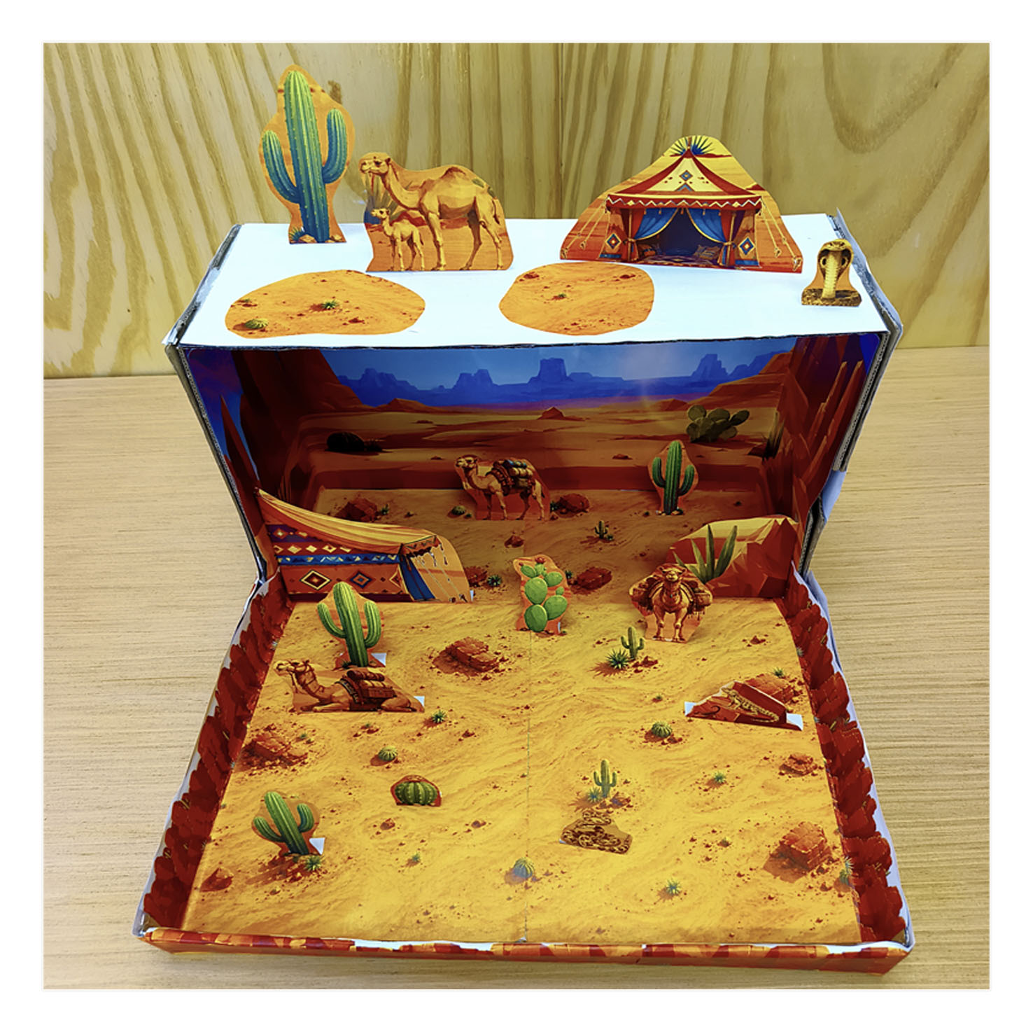 Proyecto escolar de maqueta del desierto construido en una caja de zapatos con figuras recortables