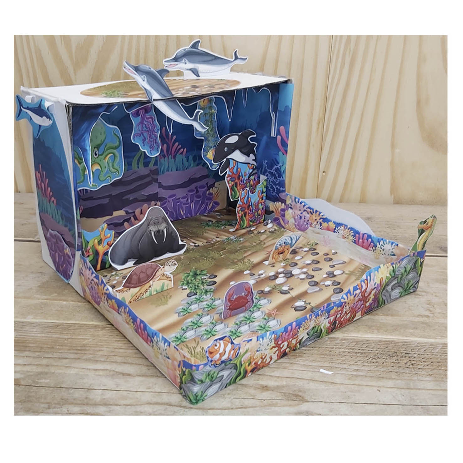 Maqueta de ecosistema acuático del océano construida en una caja con animales marinos y arrecifes de papel