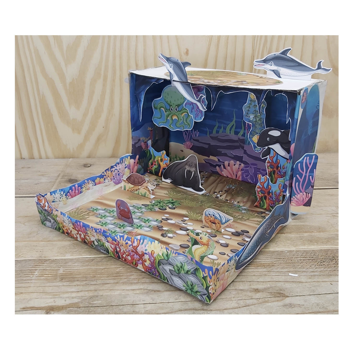 Maqueta del océano con animales marinos de papel como delfines, orca, pulpo, morsa y tortuga